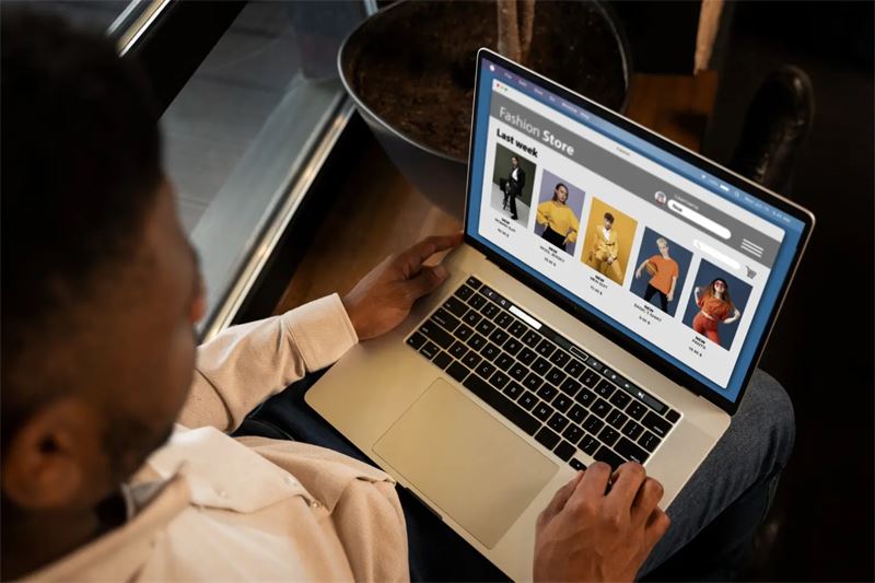 Homme consultant une boutique de mode en ligne sur son ordinateur portable