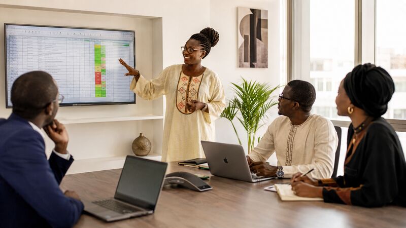Équipe commerciale réunie autour d'une table pour analyser le suivi des prospects dans un bureau à Dakar